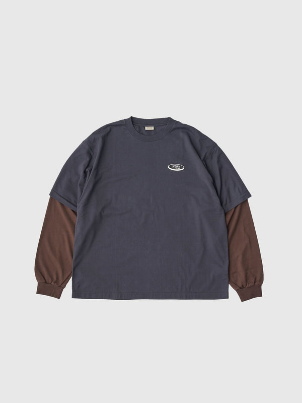 【SEDAN ALL - PURPOSE|セダンオールパーパス】OVAL LOGO LAYERED TEE/オーバルロゴレイヤードL/S Tシャツ(CHARCOAL/BROWN) - STREAM【SEDAN ALL - PURPOSE|セダンオールパーパス】OVAL LOGO LAYERED TEE/オーバルロゴレイヤードL/S Tシャツ(CHARCOAL/BROWN)STREAMM